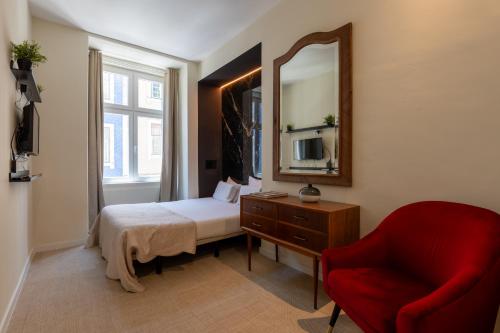 una camera da letto con un letto, uno specchio e una sedia di Lisbon Studios a Lisbona