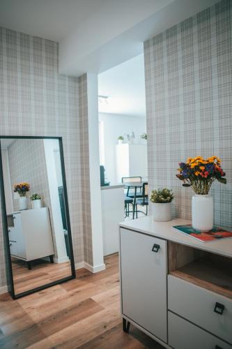 a bathroom with a mirror and flowers on a counter at Wohnen auf Zeit in Saarbrücken in Saarbrücken