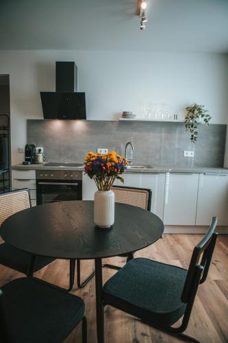 a kitchen with a table with a vase of flowers on it at Wohnen auf Zeit in Saarbrücken in Saarbrücken