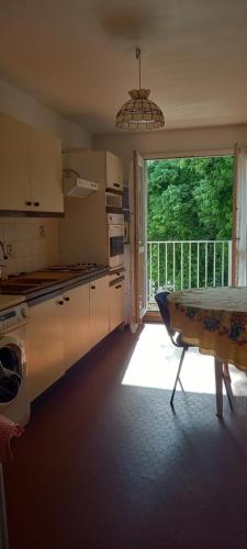 une cuisine avec une table et une grande fenêtre dans l'établissement NinaParis, aux Ulis