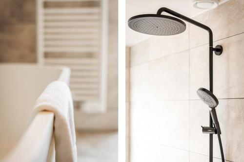 a shower with a shower head in a bathroom at Prins Hendrik Texel in Oost