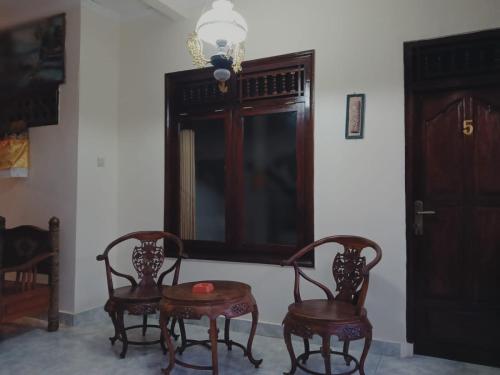 a room with two chairs and a table and a window at Sudana Homestay in Ubud City in Ubud