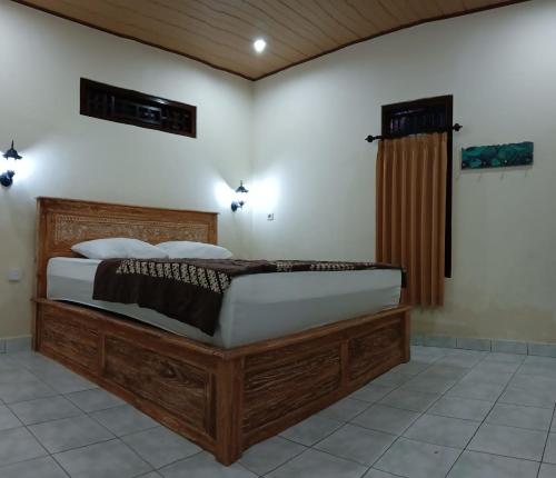 a bedroom with a large wooden bed in a room at Sudana Homestay in Ubud City in Ubud