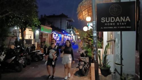a group of people walking down a street at night at Sudana Homestay in Ubud City in Ubud