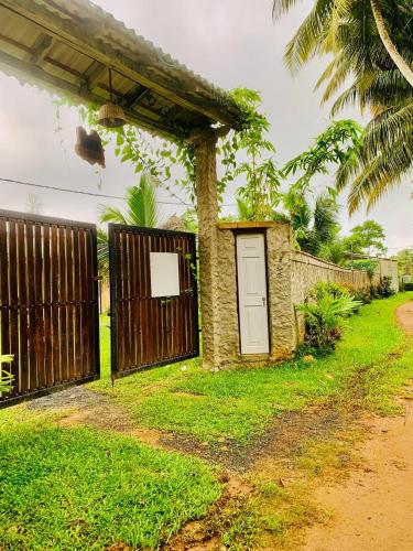 a small house with a gate and a fence at Ashok villa in Weligama