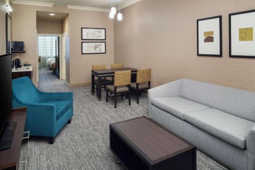 a living room with a couch and a dining room at Embassy Suites Saint Louis - Downtown in Saint Louis