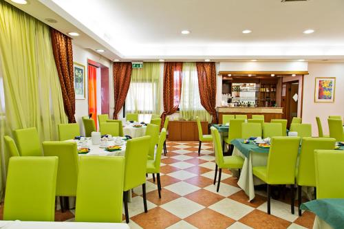 a dining room with tables and green chairs at Hotel President Pomezia in Pomezia