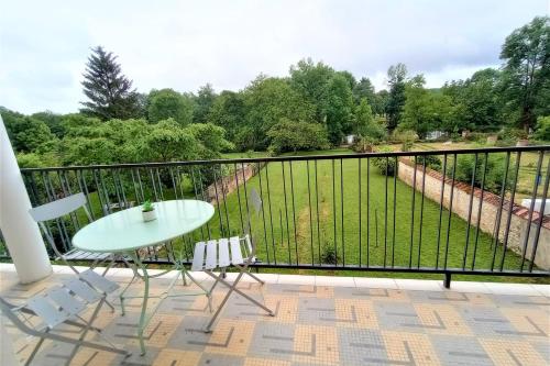 a balcony with a table and chairs and a view at Le Florin d'Or - Bords de Creuse in Saint-Gaultier