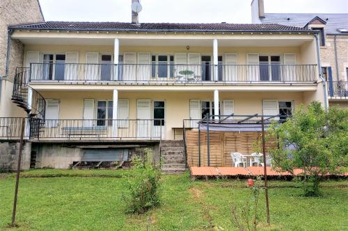 an old house with a balcony and a table on a yard at Le Florin d'Or - Bords de Creuse in Saint-Gaultier