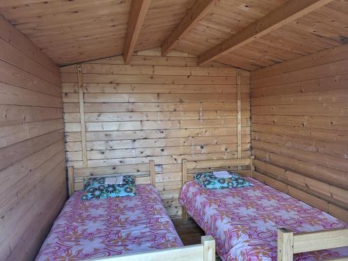 KiidjärveにあるLõunamatkadの木造キャビン内のベッド2台が備わる部屋