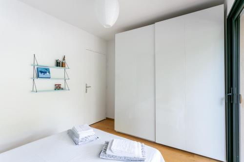 - une chambre avec des murs blancs et un grand miroir dans l'établissement Piscine, Clim, BBQ et transat, à Villevieille