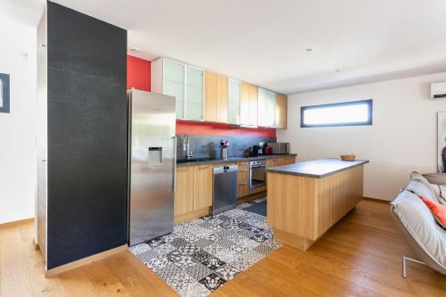 Il comprend une cuisine équipée d'un réfrigérateur en acier inoxydable et d'un canapé. dans l'établissement Piscine, Clim, BBQ et transat, à Villevieille