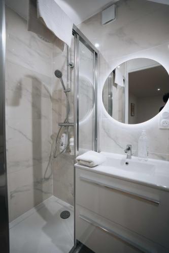 une salle de bain avec une douche, un lavabo et un miroir dans l'établissement Le Jardin de George - Le Tout Confort, à Châteauroux