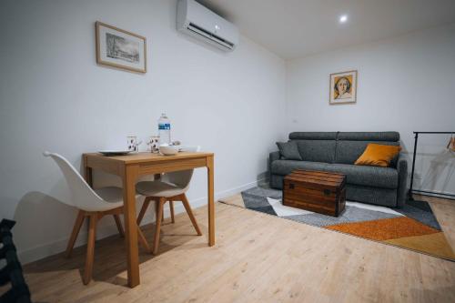 un salon avec une table et un canapé dans l'établissement Le Jardin de George - Le Tout Confort, à Châteauroux