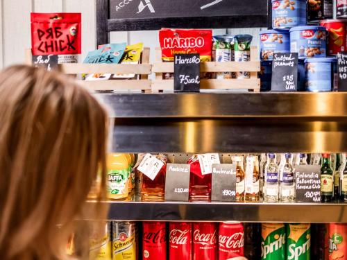 a woman in a store looking at a shelf of drinks at ibis Kyiv Railway Station in Kyiv