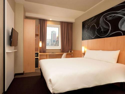 a hotel room with a large bed and a window at ibis Kyiv Railway Station in Kyiv