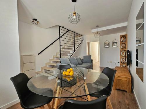 sala de estar con mesa de cristal y escalera en Dúplex Hoya del Viejo, en Las Palmas de Gran Canaria