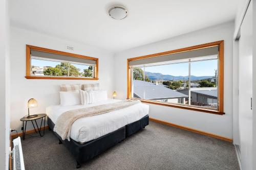 a bedroom with a large bed and a large window at Residence at 165 Great for large groups Sleeps 11 in Hobart
