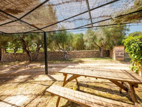 a wooden picnic table under a tent in a yard at Possessio Sa Barrala Casa del Pages in Campos