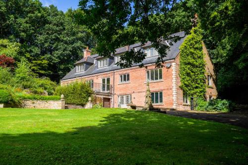 a large brick house with a green lawn in front of it at Durham City, Peaceful, Sauna, Free Parking in Durham