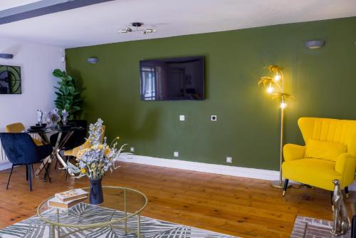 a living room with green walls and a yellow chair and a table at Durham City, Peaceful, Sauna, Free Parking in Durham