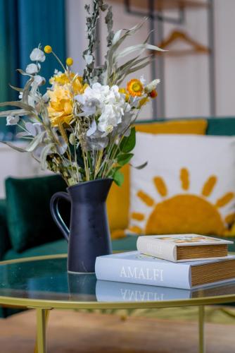 a vase with flowers sitting on a table with books at Durham City, Peaceful, Sauna, Free Parking in Durham
