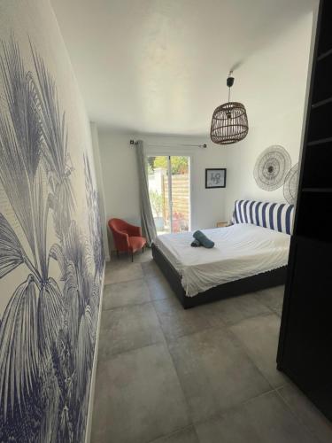 une chambre avec un lit et une chaise dedans dans l'établissement Azur Appart 4 pers - Parking - Terrasse - 10min du centre, à Cassis