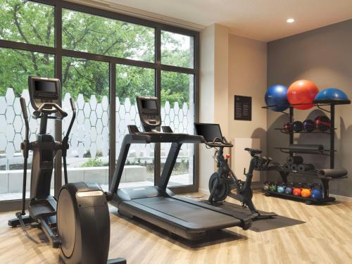 a gym with bikes and exercise equipment in front of a window at Hampton By Hilton Celle in Celle