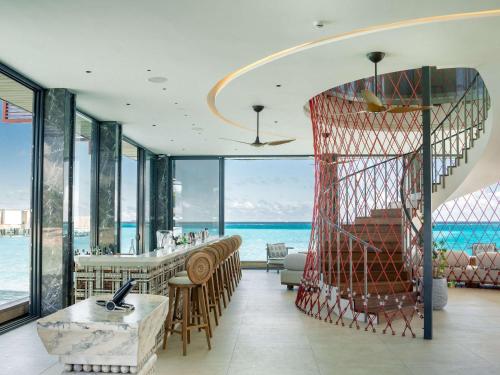 a hotel lobby with a view of the ocean at SO/ Maldives in South Male Atoll