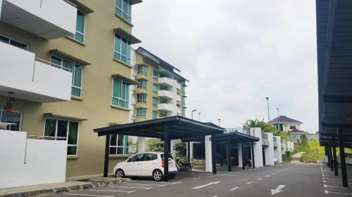 a white car parked in a parking lot next to a building at Homelite Eco Park Condominium in Miri