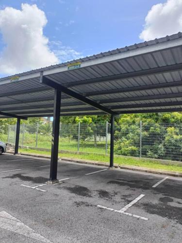 a parking lot with a large metal roof at Homelite Eco Park Condominium in Miri