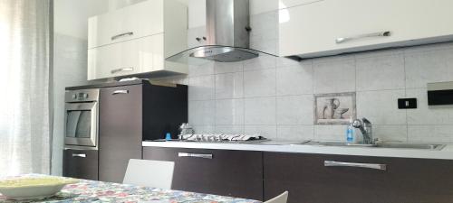 a kitchen with a sink and a refrigerator and a table at Puffetta in Pachino