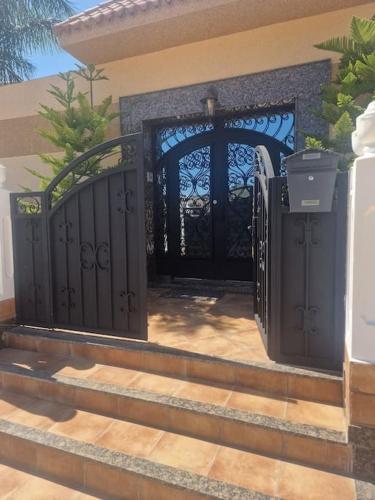 a black gate on the side of a house at Villa Fatma in Haraka