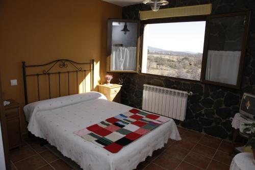 une chambre avec un lit avec une couette dessus dans l'établissement Hostal Restaurante Alto Rey, à Arroyo de las Fraguas