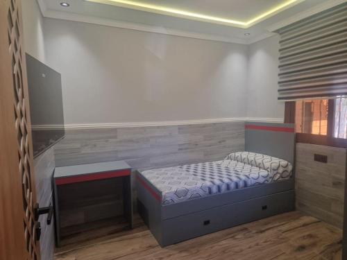 a small bedroom with a bed and a desk at Villa Fatma in Haraka