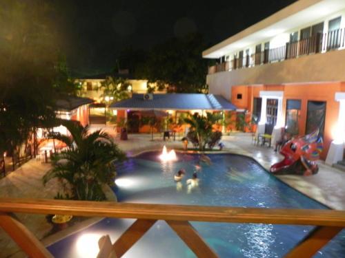 two people in a swimming pool at night at Hotel Puerto Libre in Puerto Barrios