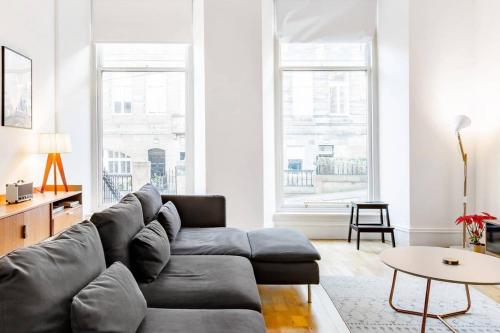 a living room with a couch and a table at Incredible contemporary flat in heart of west end in Glasgow