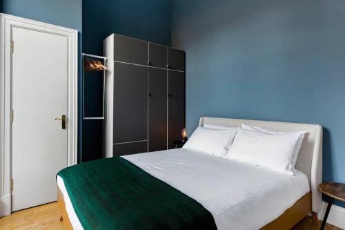 a bedroom with a large bed with a blue wall at Incredible contemporary flat in heart of west end in Glasgow