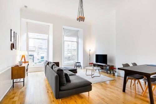 a living room with a couch and a table at Incredible contemporary flat in heart of west end in Glasgow