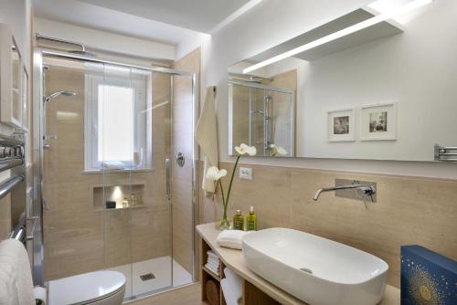 a bathroom with a sink and a shower at Tosca With Beach & Breakfast Included in Viareggio