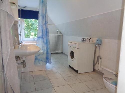 a bathroom with a washing machine and a sink at Ferienwohnung mit Hundebetreuung in Garstedt