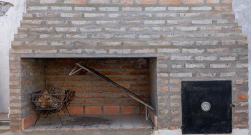 a brick wall with a black door and a basket at Apartamiento temporario Catamarca in San Fernando del Valle de Catamarca