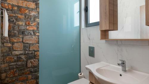 a bathroom with a white sink and a brick wall at Family Rhodes Villa 4 Bedrooms Villa Summer Memories Private Pool Lindos in vlicha