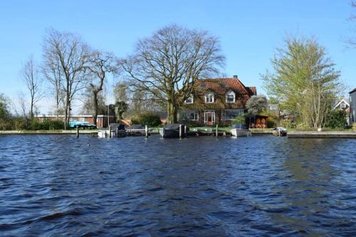 a house is inundated with water in front of a house at Hollema Logies - De Pastorie in Earnewâld