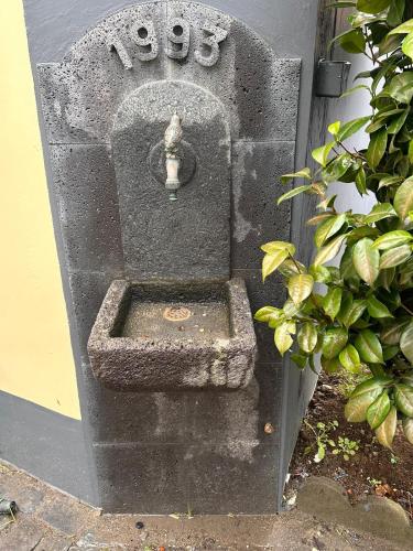 a stone fountain with a sink in the side of a building at Azor International Hostel in Ponta Delgada