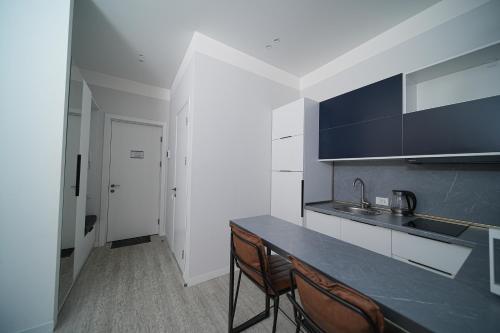 a kitchen with a counter and chairs in a room at Sweet Home Apart-Hotel in Yerevan