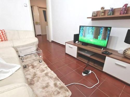 un salon avec un canapé blanc et une télévision dans l'établissement Private Double Room in T4 Apartment, à Almada