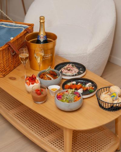 a table with plates of food and a bottle of wine at Domaine des Thermes in Awans
