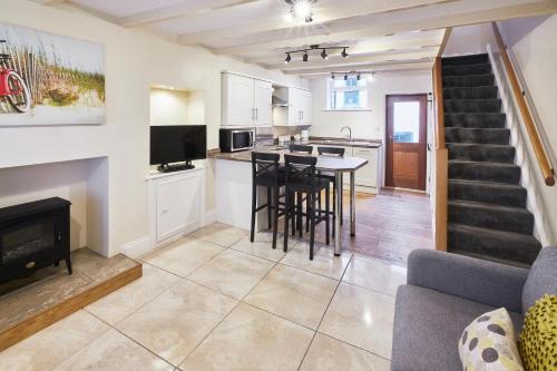 a kitchen and living room with a table and a fireplace at Host & Stay - Sea Haven in Staithes