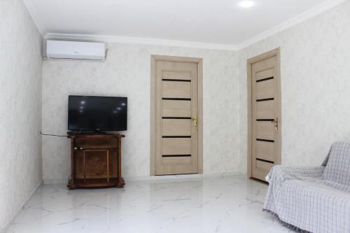 a living room with a tv and a couch at Cozy House in Gabala